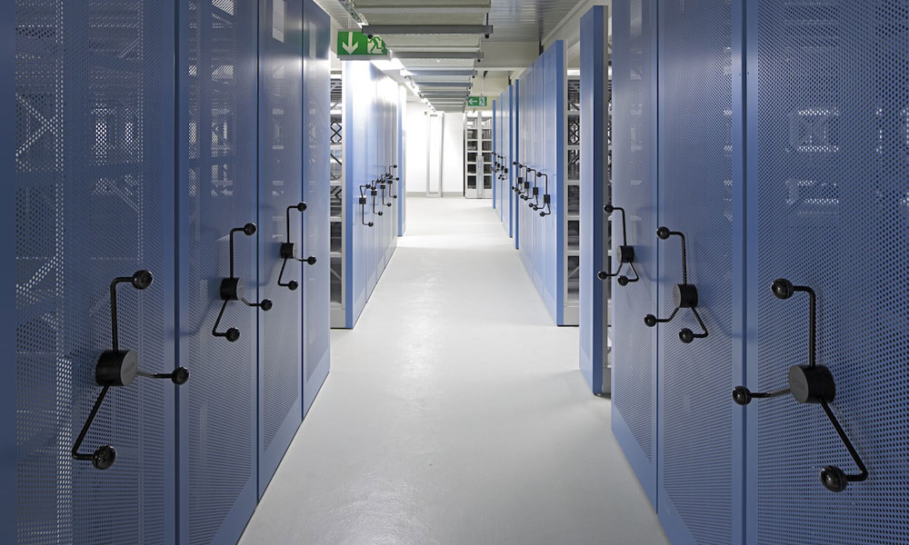 Verfahrbare Archivregale mit Drehsternantrieb und blauen gelochten Vorsatzwänden